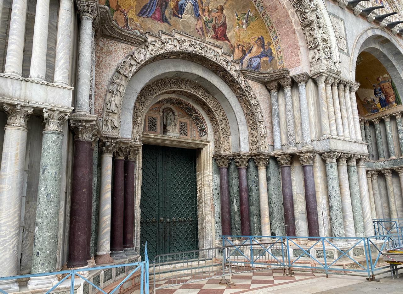 Portal of St Mark's Basilica in Venice — marble columns, mosaics, centuries of patina as part of the identity