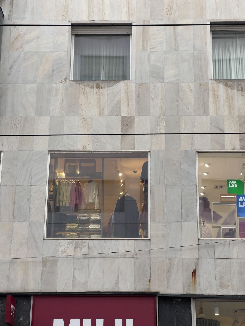 Modern marble facade with discoloration and rust stains — clean lines, but visible aging